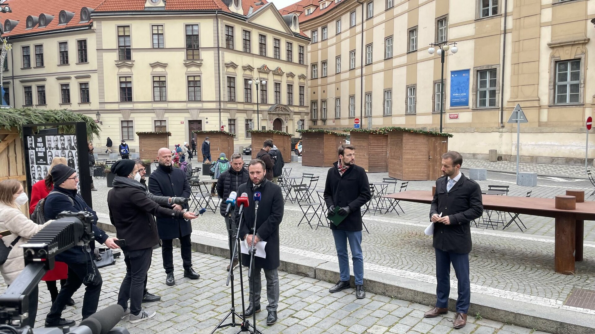 Tisková konference k uzavření vánočních trhů. U mikrofonu radní Jan Chabr, v pozadí Libor Votruba a Jan Dell ze společnosti Taiko, vpravo radní Vít Šimral. V pozadí na Mariánském náměstí stánky, které se letos postavily zřejmě jen proto, aby se zase zbouraly. tiskovka magos trhy