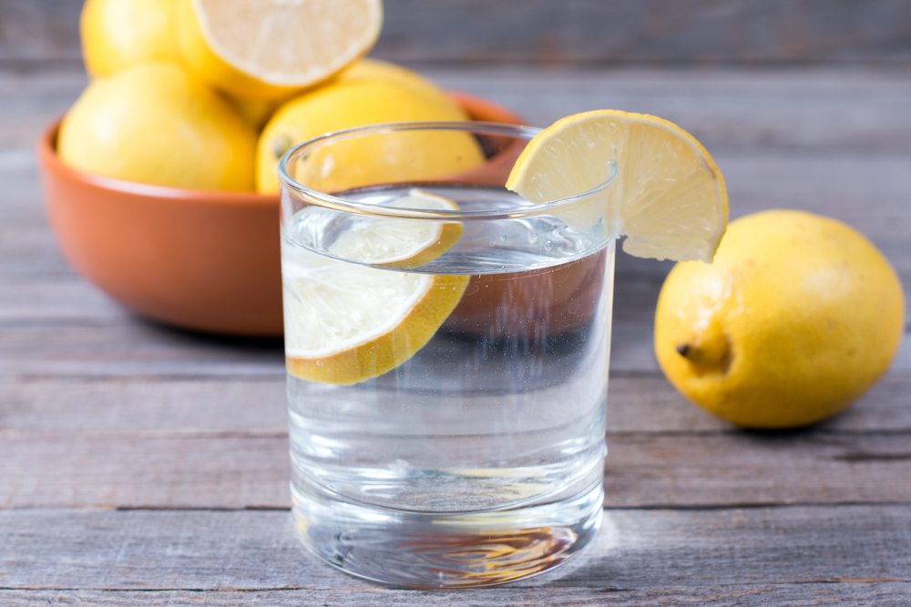 Zkuste ráno vypít vlažnou vodu s citronem, která podpoří činnost střev a napomůže detoxikaci. shutterstock 524619709