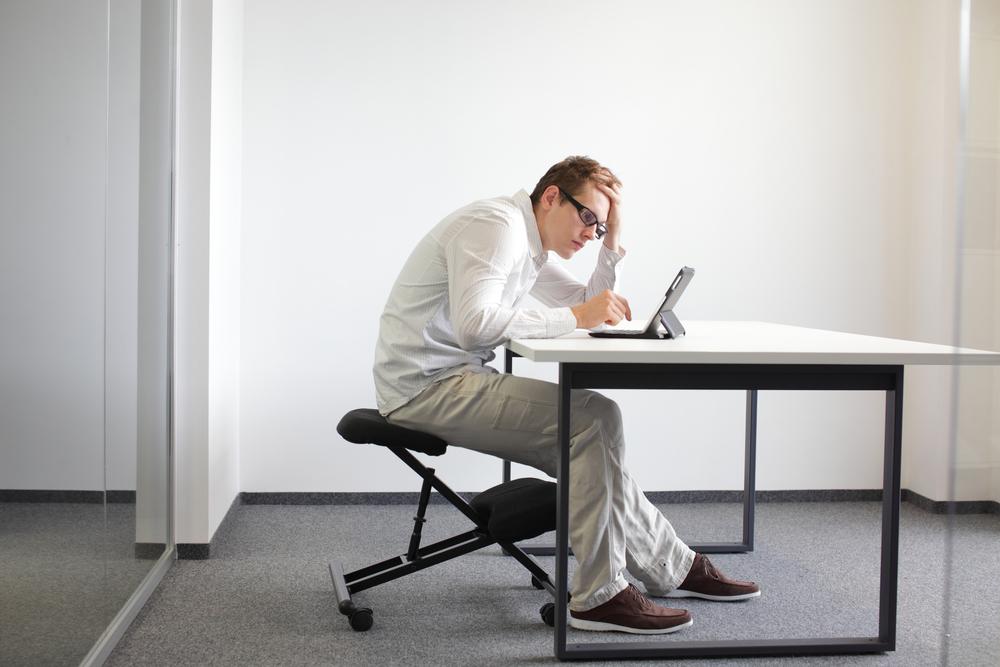 Častým problémem bývá nesprávné držení těla, především pak sed s kulatými zády předklonem či předsunem hlavy. ergonomie shutterstock 159890216