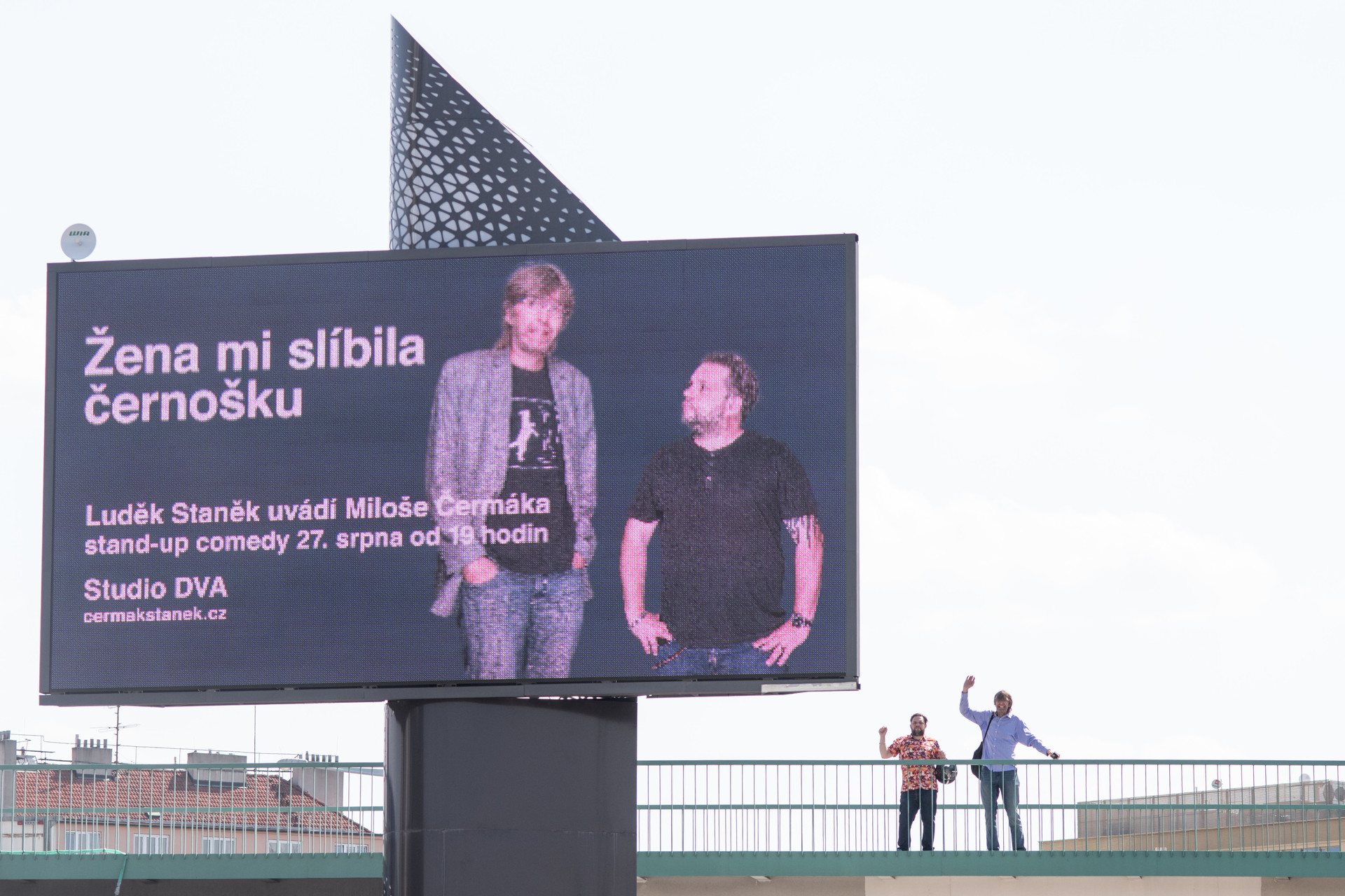 Stand-up comedy si buduje tradici už i na klasických nosičích. Ani z nich moc ale nevíte, co představení přinese. Možná to ti dva za billboardem ale vysvětlí... rv1 2656