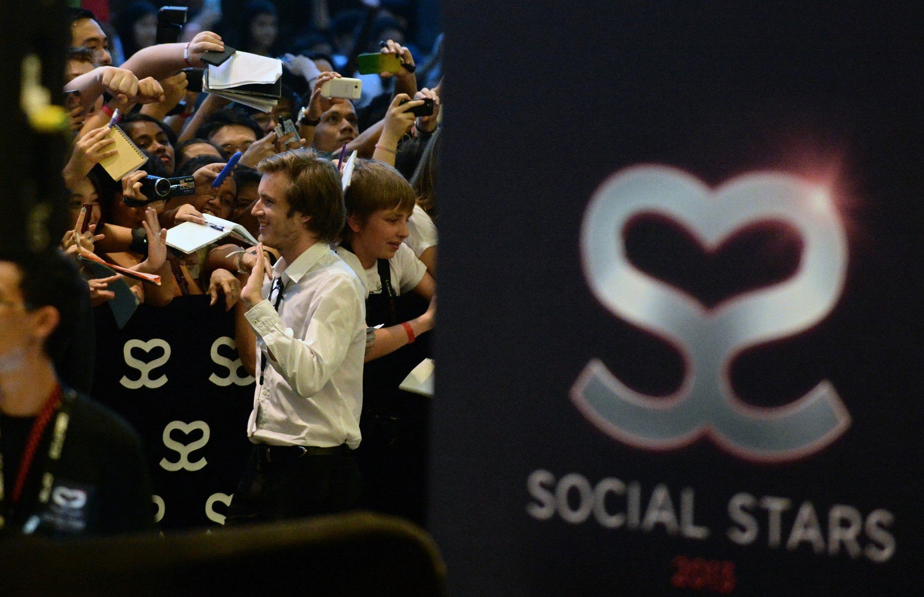 Swedish video game commentator Felix Kjellberg, aka PewDiePie (L), acknowledges his fans as he arrives to attend the Singapore Social Star Awards at the Marina Bay Sands in Singapore on May 23, 2013. pewdiepie